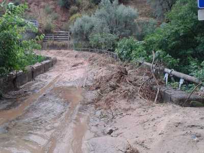 La strada che costeggia il dirupo: l'alluvione l'ha trasformata in un fiume di fango